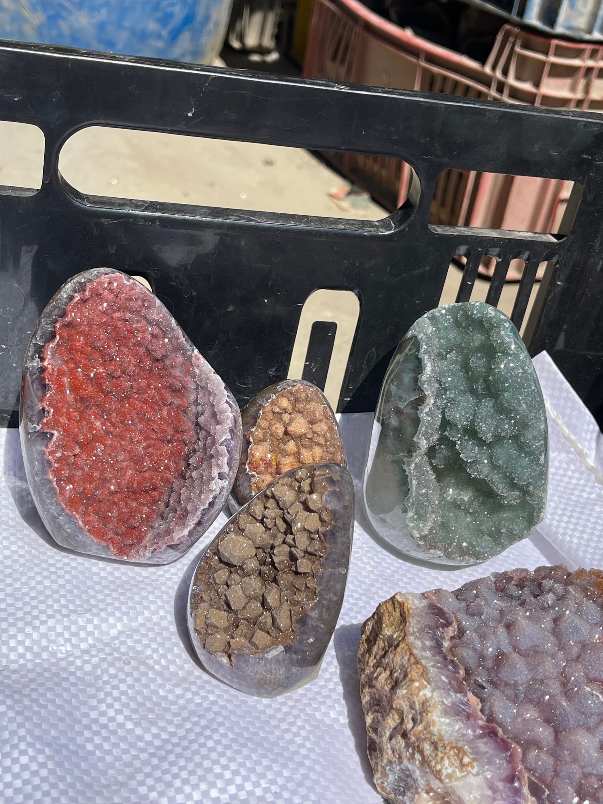 Cuatro geodas con interiores de distinto color —rojo, ocre, verde— y una de amatista
