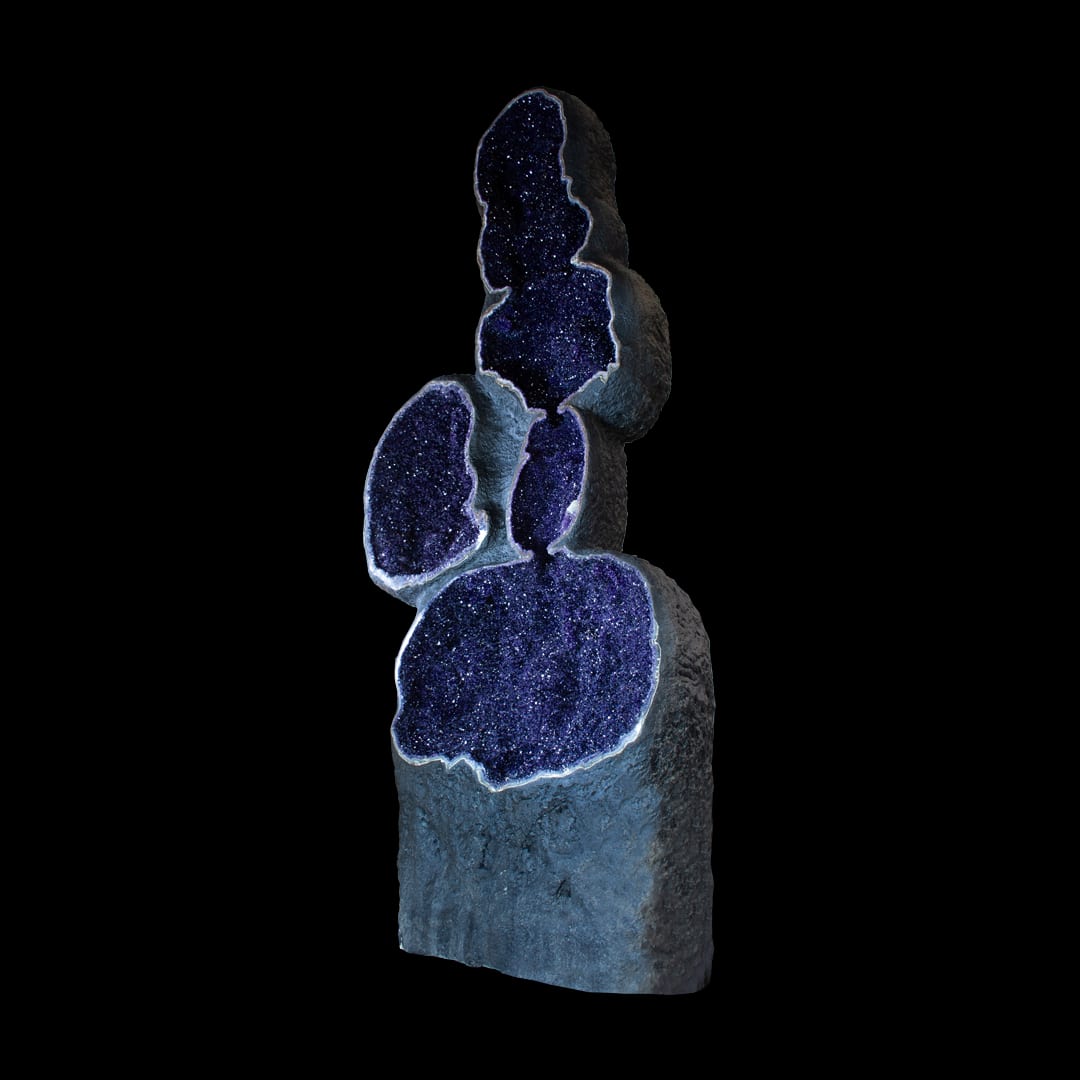A giant amethyst geode with several cavities, standing upright