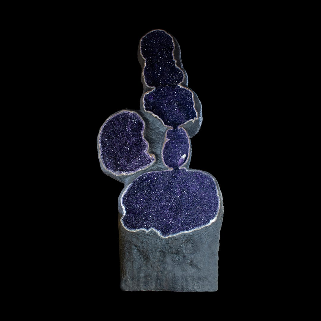 A giant amethyst geode with several cavities, standing upright