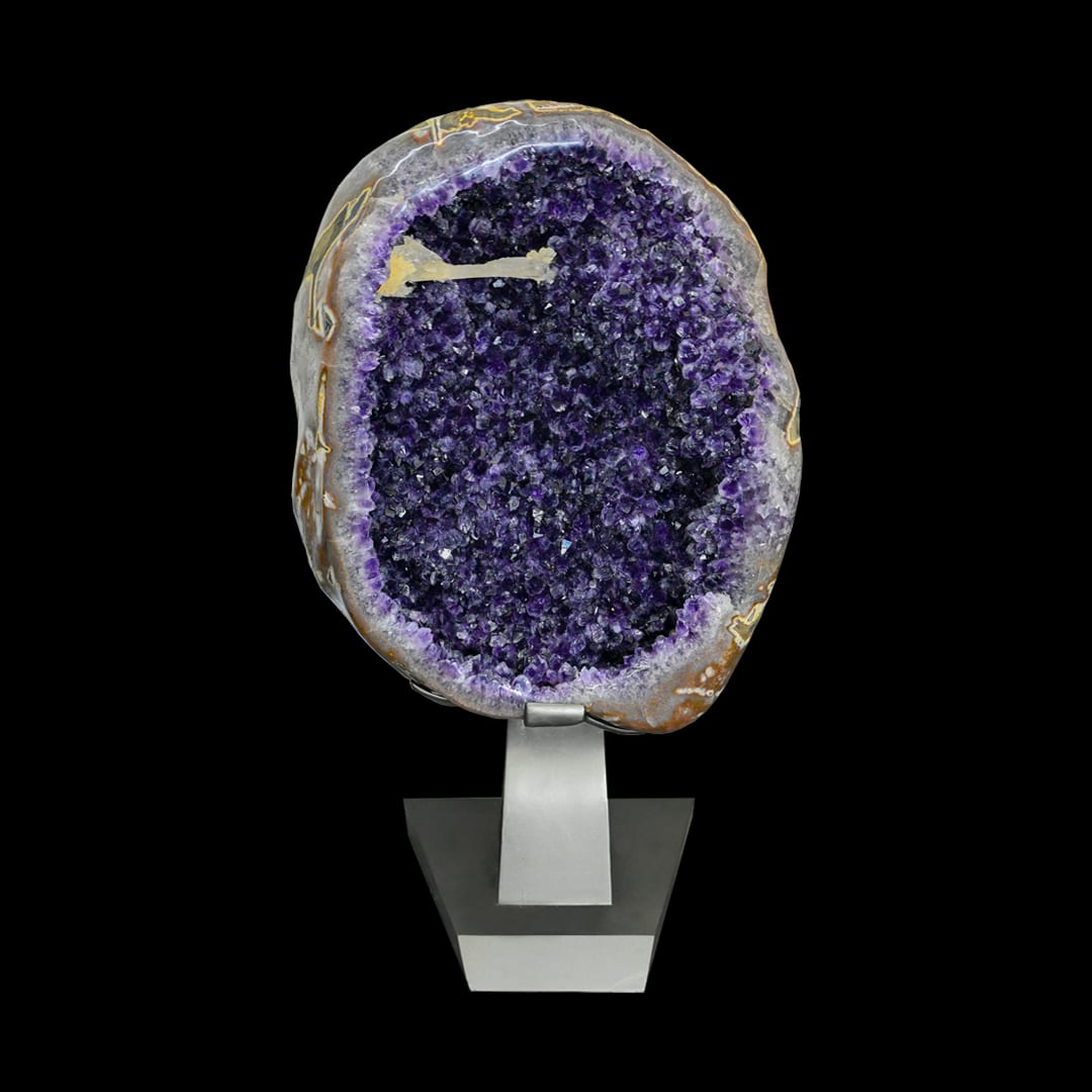 An open egg-shaped amethyst geode on a metal stand