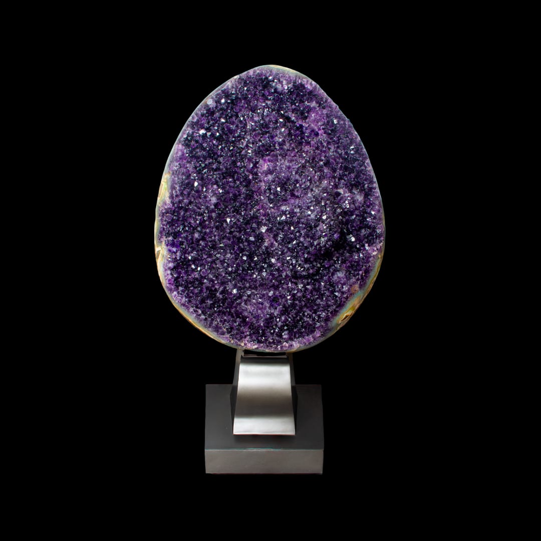 An open egg-shaped amethyst geode on a metal stand