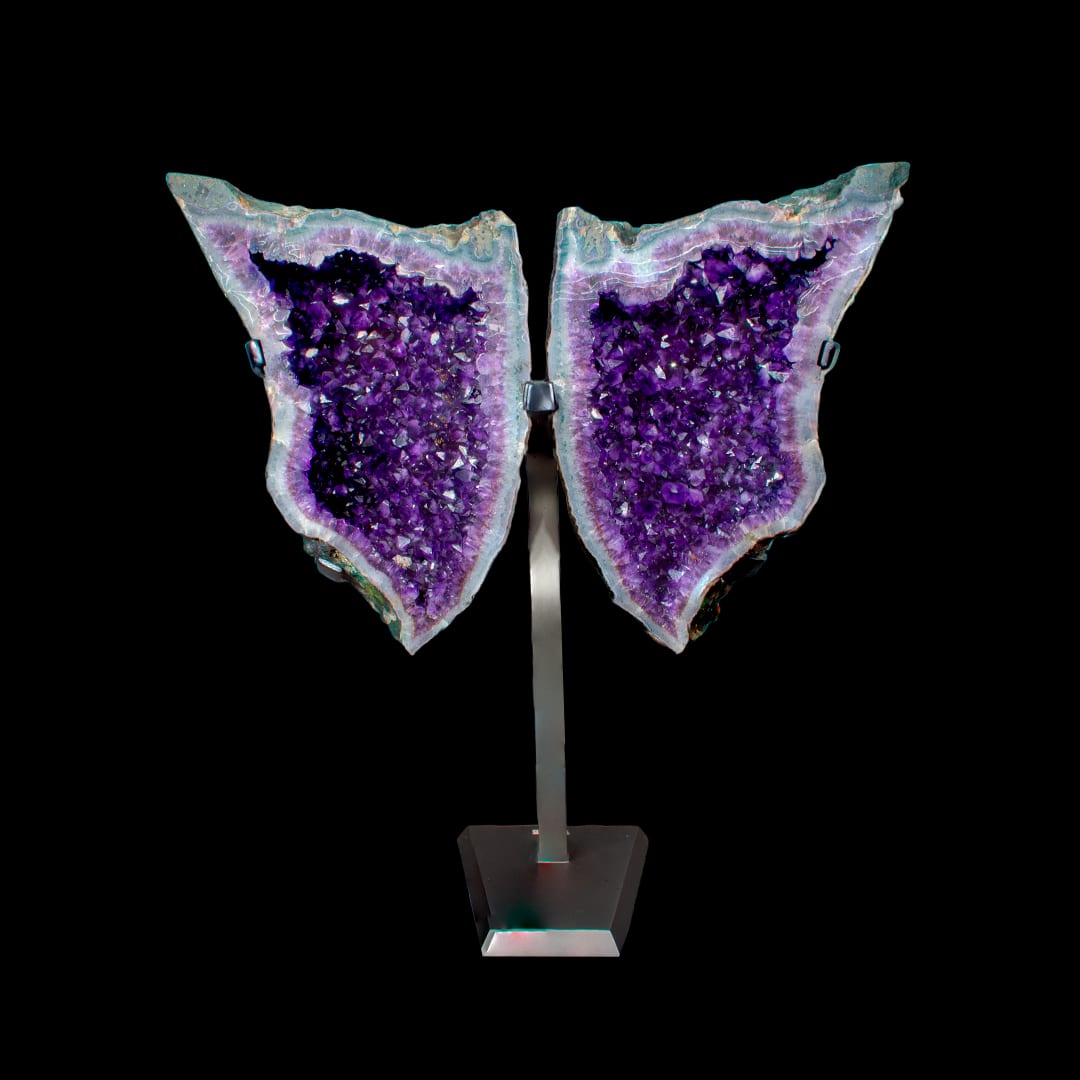 Two halves of an amethyst geode mounted like wings, on a metal stand