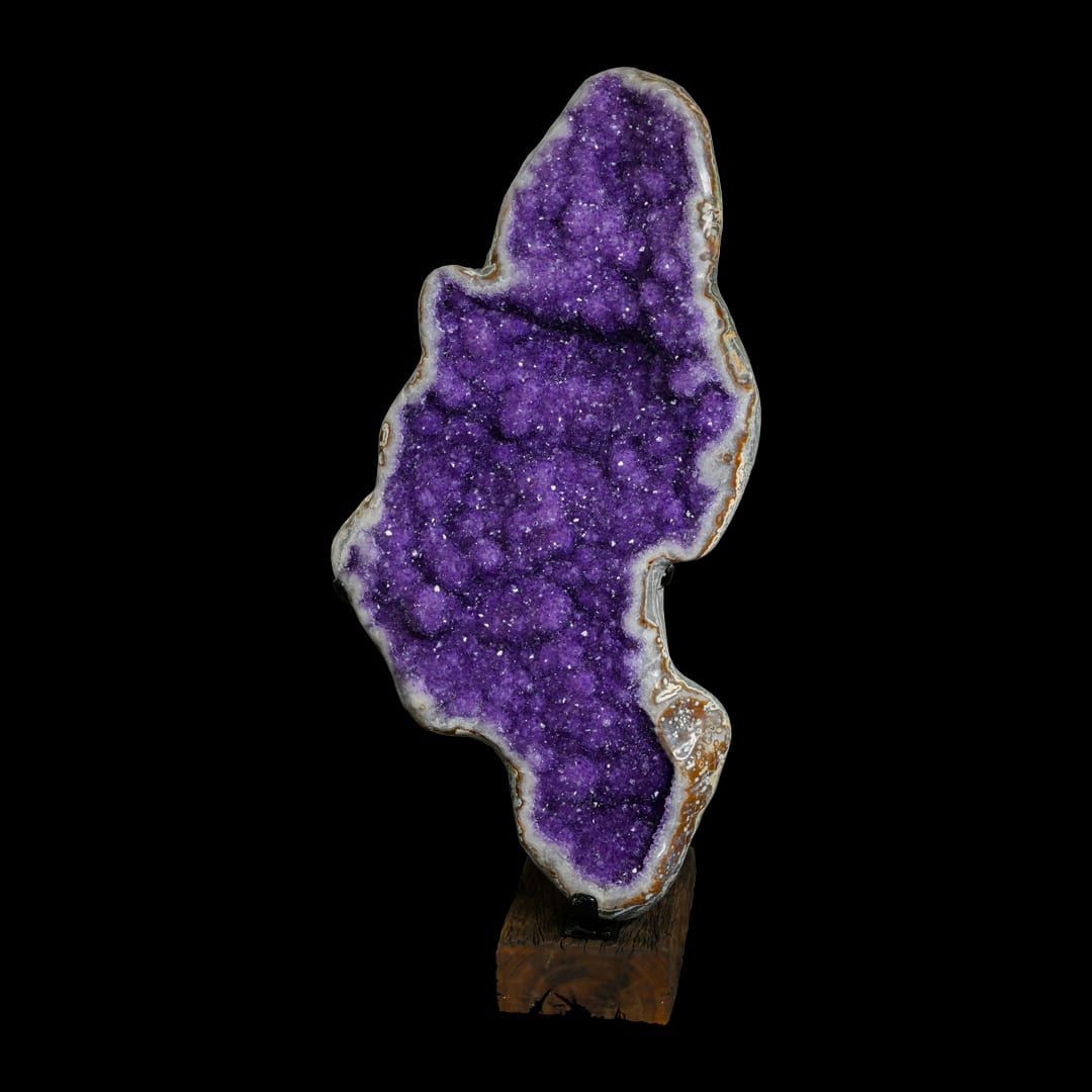 An elongated amethyst geode on a wooden base