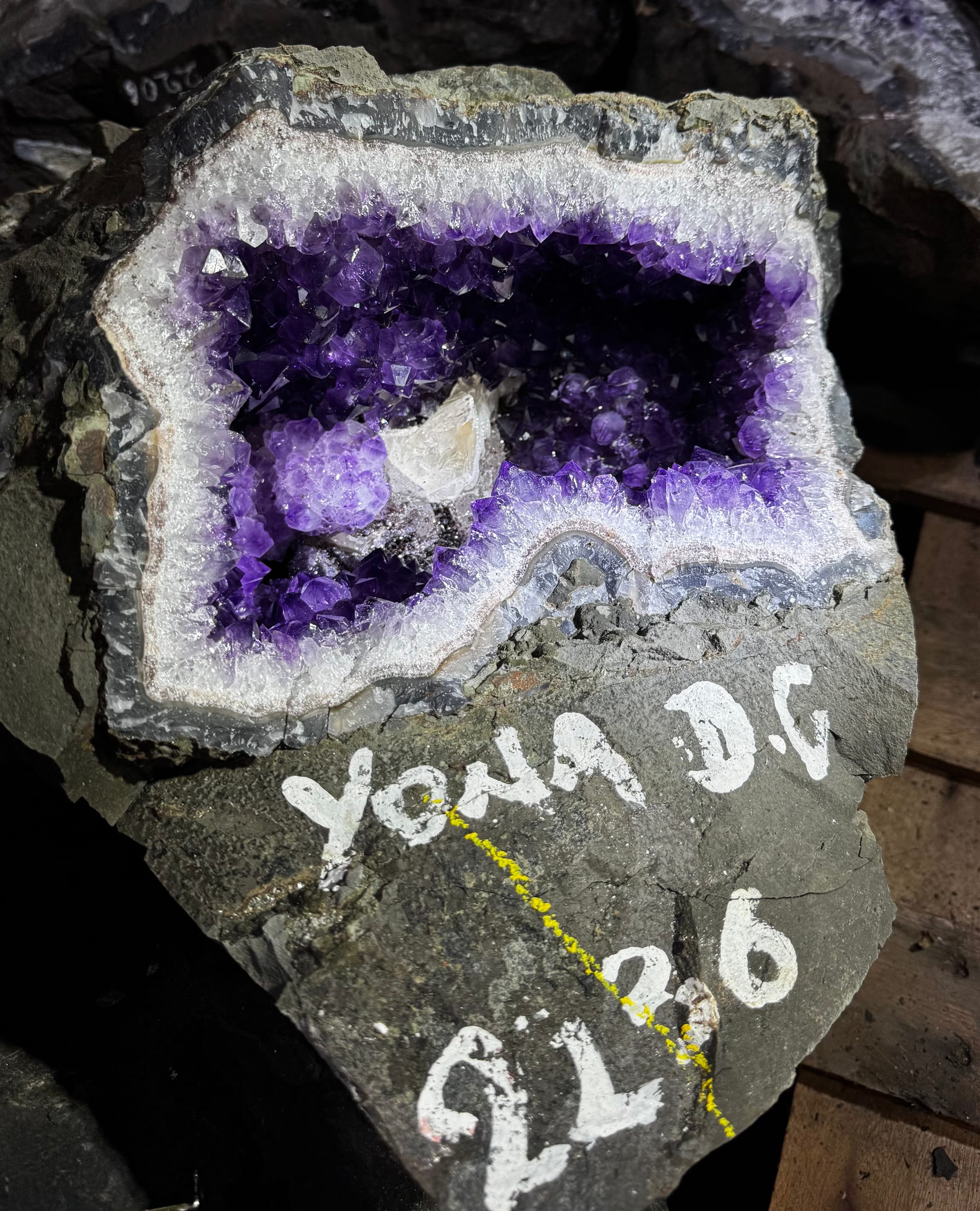 Geoda de amatista recién salida de la cantera, con letras y números pintados en blanco sobre el basalto